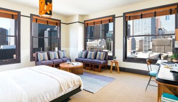 Freehand Los Angeles gay-friendly hotel room. Downtown city views from the windows. Modern design with bed, seating area, and desk.
