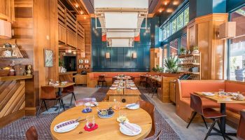 Freehand Los Angeles gay-friendly hotel restaurant. Wood-paneled walls, booths, tables set with plates and glasses. Warm, inviting space.