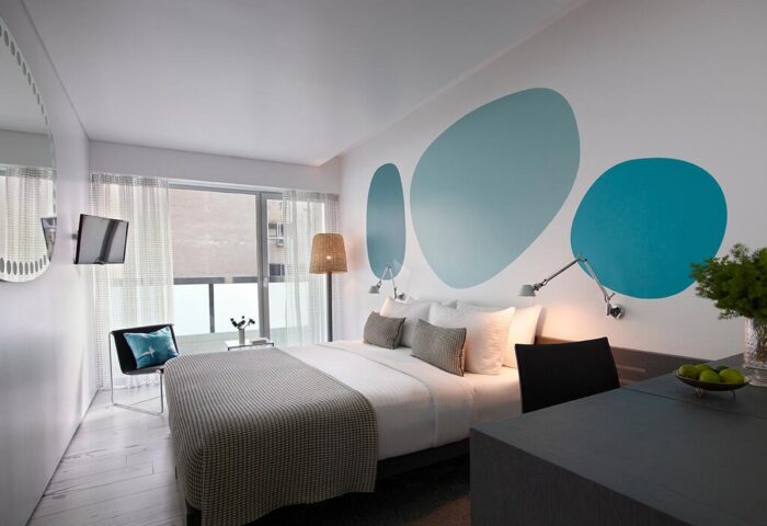 Fresh Hotel: Modern room at a gay-friendly hotel. Features a bed, desk, & blue wall art. Perfect for gay men's travel.