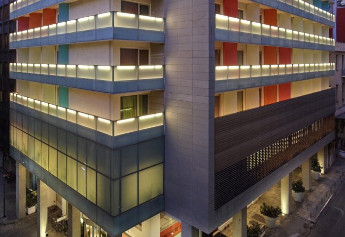Exterior of Fresh Hotel, a gay-friendly hotel. Modern architecture with colorful accents and illuminated balconies. Ideal for gay travel.