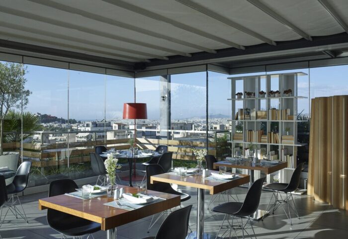 Fresh Hotel's gay-friendly rooftop restaurant in Athens, Greece. Tables are set with city view. Modern design, ideal for gay men travelers.
