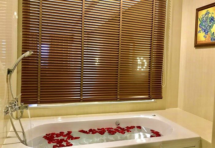 Bathtub with rose petals at Furama Chiang Mai, a gay-friendly hotel. Relax in style during your Chiang Mai vacation.
