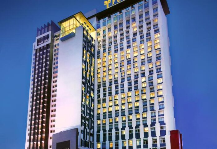 Furama Hotel Bukit Bintang exterior view at dusk. Gay-friendly hotel in Kuala Lumpur, Malaysia. Modern architecture, illuminated windows.