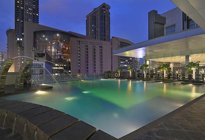 Furama Hotel Bukit Bintang pool at night. Gay-friendly hotel in Kuala Lumpur with rooftop pool and city views. Luxury travel for gay men.