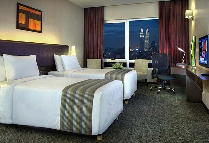 Furama Hotel Bukit Bintang twin room. Gay-friendly hotel with city view of Kuala Lumpur. Comfortable beds, desk, and modern amenities.