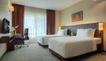 Furama Hotel Bukit Bintang twin room. Gay-friendly hotel with two beds, desk, and tv. Comfortable stay in Kuala Lumpur.