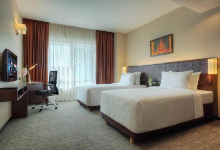 Furama Hotel Bukit Bintang twin room. Gay-friendly hotel with two beds, desk, and tv. Comfortable stay in Kuala Lumpur.