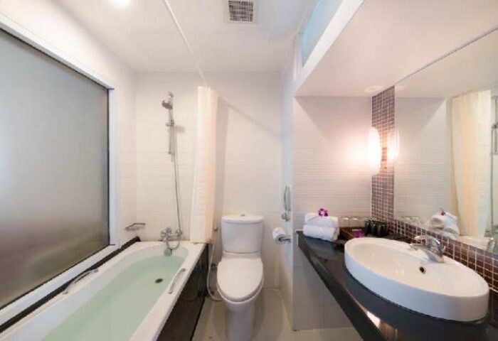 Bathroom at Furama Silom Hotel Bangkok, a gay-friendly hotel. Features a bathtub, toilet, sink, and mirror. Modern design. #gaytravel
