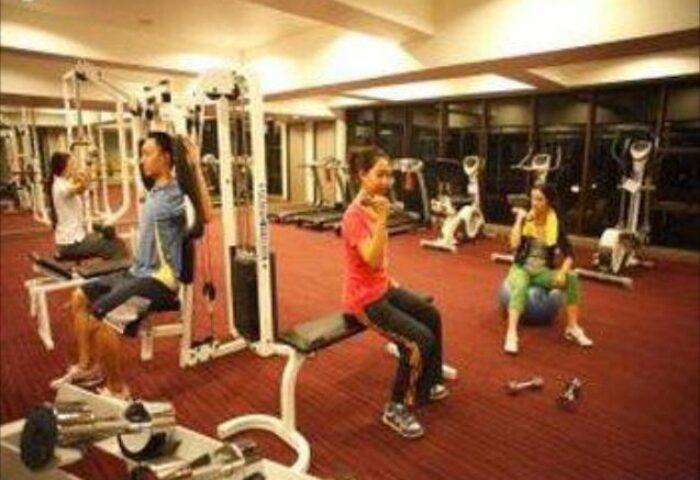 Furama Silom Hotel Bangkok gym. Guests working out with weights and machines in the gay-friendly hotel's fitness center.