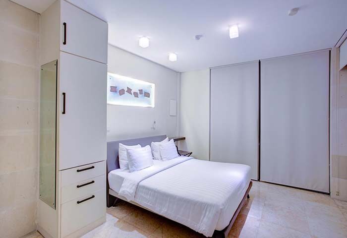 FuramaXclusive Ocean Beach Hotel Seminyak gay-friendly room. Clean, modern design with white linens. Ideal for gay travel in Seminyak, Bali.