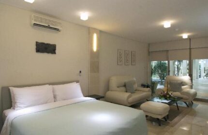 FuramaXclusive Ocean Beach Hotel Seminyak suite. Gay-friendly hotel room with bed, seating area, and outdoor view in Seminyak, Bali.