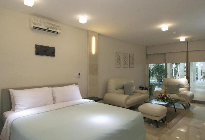 FuramaXclusive Ocean Beach Hotel Seminyak suite. Gay-friendly hotel room with bed, seating area, and outdoor view in Seminyak, Bali.
