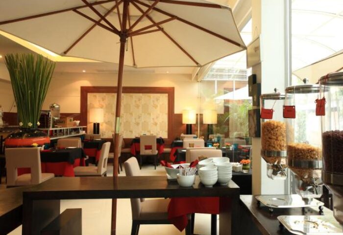 Breakfast buffet at FuramaXclusive Sathorn Hotel, Bangkok. Gay-friendly hotel dining area with cereal dispensers and outdoor umbrella.
