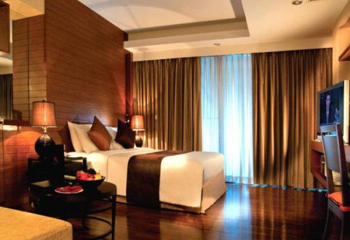 FuramaXclusive Sathorn Hotel Bangkok room. Gay-friendly hotel with modern design, wood accents, and warm lighting. Comfortable stay in Bangkok.