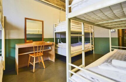 G Guesthouse Itaewon in Seoul dorm room. Gay-friendly hotel with bunk beds, desk, and chair. Budget-friendly lodging for gay travelers.