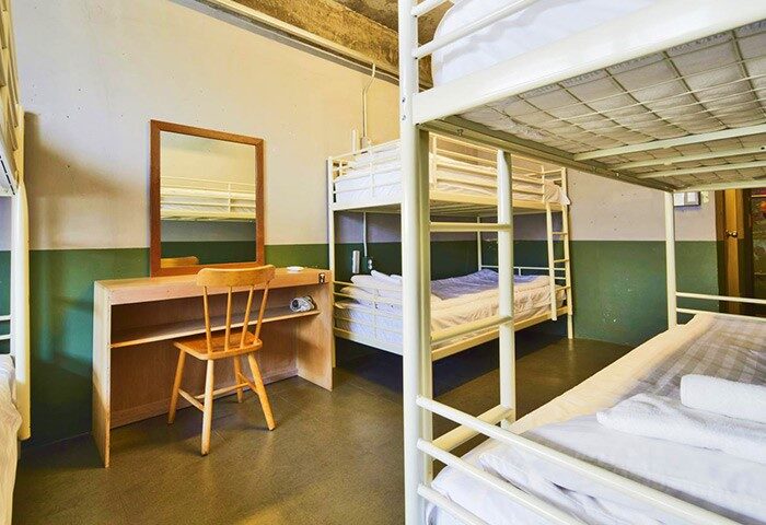 G Guesthouse Itaewon in Seoul dorm room. Gay-friendly hotel with bunk beds, desk, and chair. Budget-friendly lodging for gay travelers.