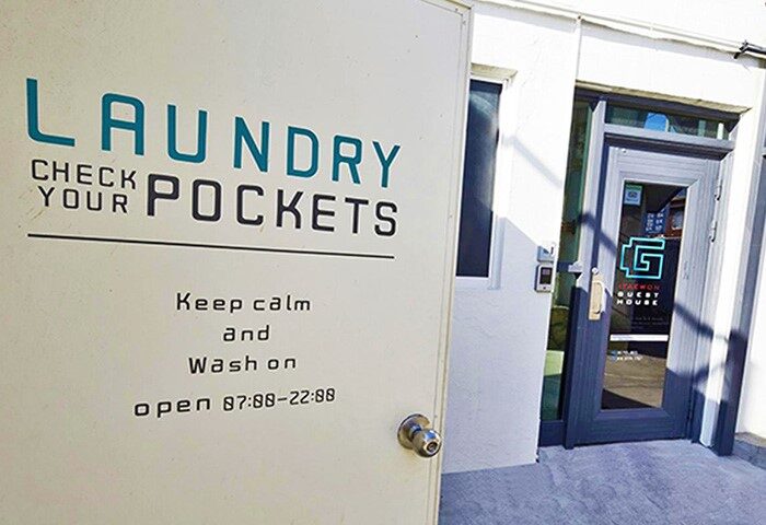 Laundry room at G Guesthouse Itaewon in Seoul. Gay-friendly hotel with laundry service. Check your pockets sign. Keep calm and wash on.