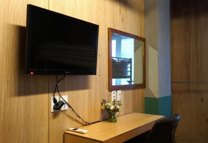 Room at G Guesthouse Itaewon in Seoul. TV, desk, mirror, and chair. Gay-friendly hotel for gay men traveling in South Korea.