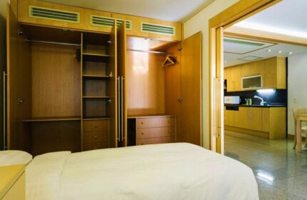 GV Residence gay-friendly hotel room. Bedroom with open closet and view into the kitchen. Gay travel lodging at this residence.