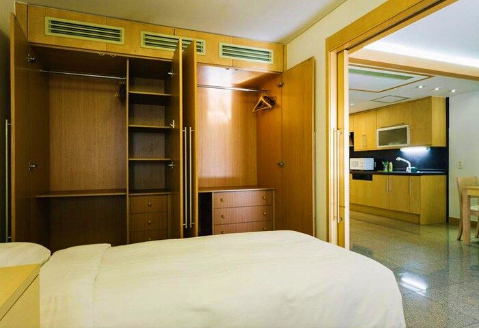 GV Residence gay-friendly hotel room. Bedroom with open closet and view into the kitchen. Gay travel lodging at this residence.