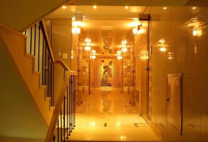 GV Residence, a gay-friendly hotel: Hallway view with stairs. Golden walls and floor, illuminated by sconces, lead to an ornate artwork.