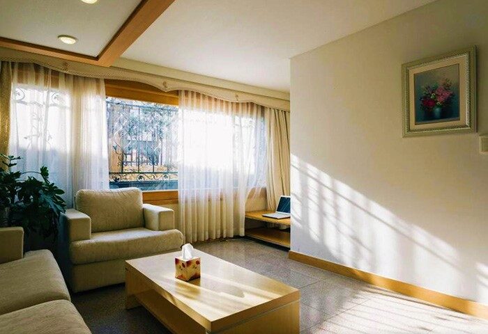 GV Residence, a gay-friendly hotel: Living room with couch, chair, coffee table, and window. Ideal for gay men's travel, a welcoming space.