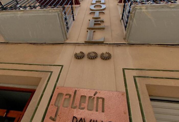 Facade of Galeon, a gay-friendly hotel. Balconies with awnings, HOTEL sign, and Galeon Pavillon nameplate. Gay travel lodging.