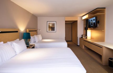 Galeria Plaza Reforma hotel room. Two beds with white linens, TV, and modern decor. Gay-friendly hotel for gay men travelers in Reforma.