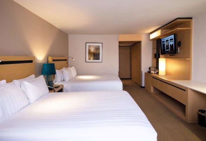Galeria Plaza Reforma hotel room. Two beds with white linens, TV, and modern decor. Gay-friendly hotel for gay men travelers in Reforma.
