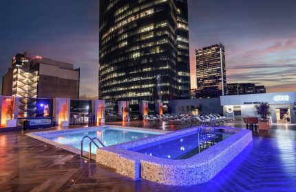Galeria Plaza Reforma's rooftop pool at dusk. Gay-friendly hotel with city views, gym, and yoga haus. A perfect spot for gay travelers.