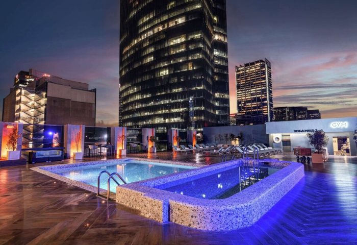 Galeria Plaza Reforma's rooftop pool at dusk. Gay-friendly hotel with city views, gym, and yoga haus. A perfect spot for gay travelers.