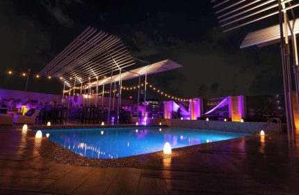 Galeria Plaza Reforma gay-friendly hotel pool at night. Rooftop pool with lights, tables, and chairs. A great place for gay men to relax and enjoy.