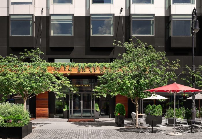 Gansevoort Meatpacking NYC: Gay-friendly Hotel entrance. Outdoor seating area with red umbrella. Stylish facade of the Gansevoort Hotel.