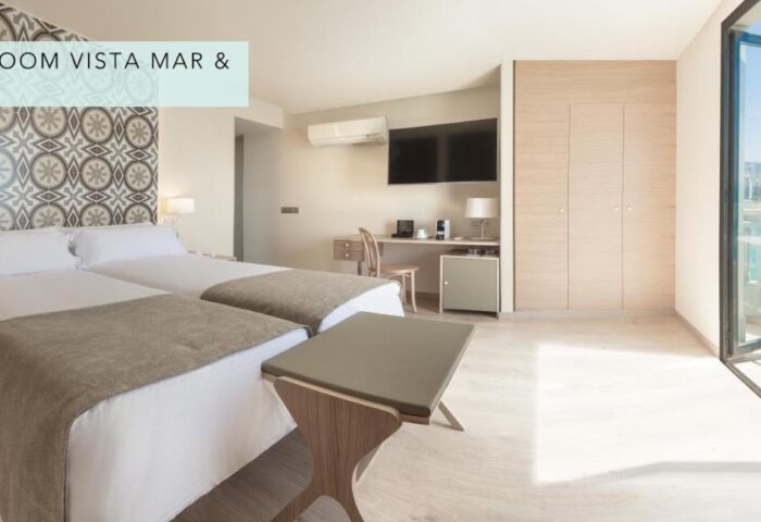 Gastrohotel Boutique RH Canfali gay-friendly hotel room with twin beds, desk, and sea view balcony. Ideal for gay travelers.