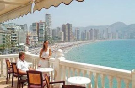 Gastrohotel Boutique RH Canfali's balcony view. Couple enjoying the beach scenery. Gay-friendly hotel in Spain. Coastal city skyline.