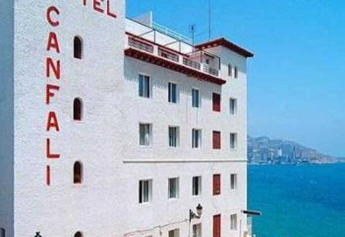 Gastrohotel Boutique RH Canfali, a gay-friendly hotel. Exterior view of the white building with red lettering, near the sea.