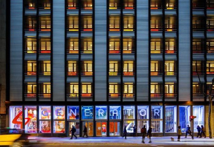 Facade of Generator Barcelona, a gay-friendly, pet-friendly hotel. The building has many windows and the name is displayed across the storefront.