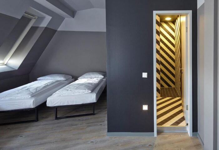 Generator Berlin Mitte hotel room. Gay-friendly design with twin beds, modern decor, and a bathroom featuring bold black and white stripes.