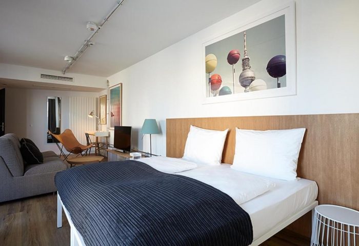 Generator Berlin Mitte gay-friendly hotel room. Double bed with TV Tower picture, desk, and sofa. Modern design, comfortable for gay travelers.