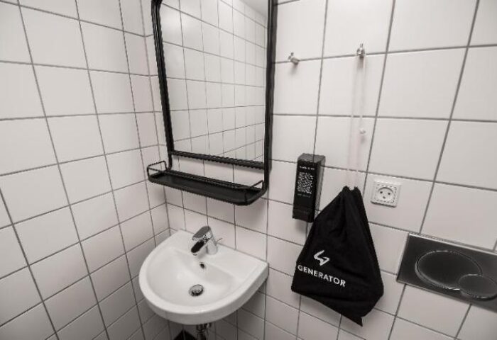 Generator Copenhagen hotel bathroom. Sink, mirror, and Generator bag. Gay-friendly hotel in Copenhagen, Denmark.