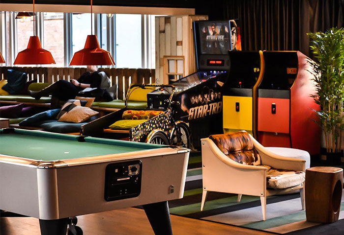 Generator Copenhagen gay-friendly hotel's game room. Pool table, Star Trek pinball, arcade games, and chill area. Modern design, fun for gay travelers.