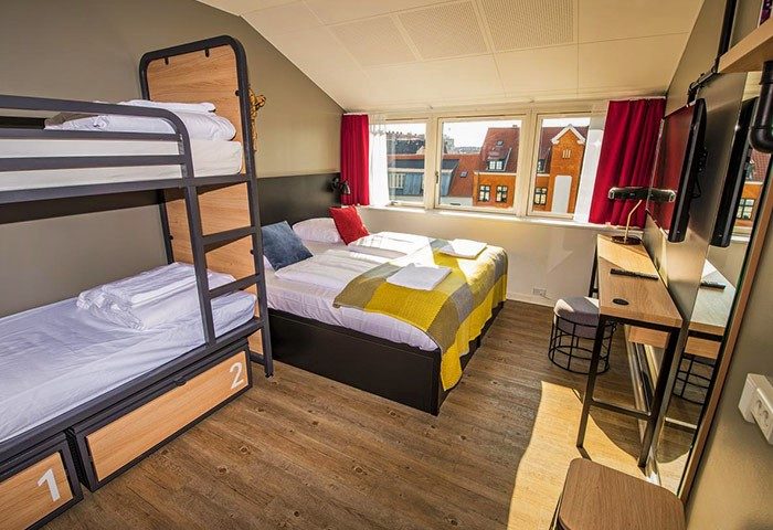 Generator Copenhagen gay-friendly hotel room. Bunk beds, double bed, desk, and a view of Copenhagen. Modern design for gay travelers.