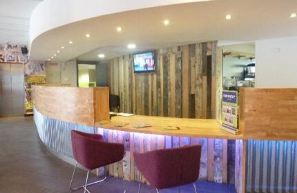 Generator Hostel Dublin reception area. Modern design, wood paneling, and stylish seating. Gay-friendly hotel for gay men travel advice.