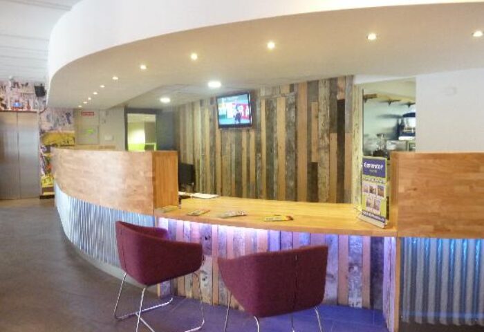 Generator Hostel Dublin reception area. Modern design, wood paneling, and stylish seating. Gay-friendly hotel for gay men travel advice.
