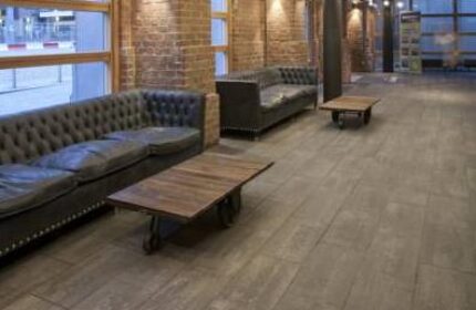 Generator Hostel Dublin interior. Lounge area with leather sofas and wooden tables. Gay-friendly hotel with modern design.