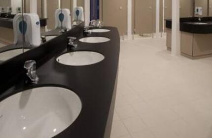 Generator Hostel Dublin bathroom interior. Reviews of this gay-friendly hotel show clean communal sinks and toilet stalls.