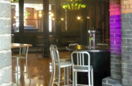 Interior of Generator Hostel Dublin, a gay-friendly hotel. Bar stools and tables are visible in this review image.