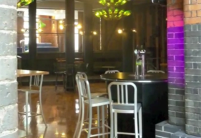 Interior of Generator Hostel Dublin, a gay-friendly hotel. Bar stools and tables are visible in this review image.