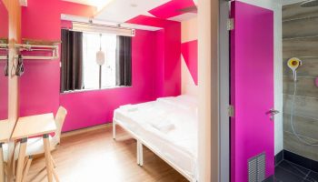 Generator London gay-friendly hotel room. Bright pink walls, bed, desk, and shower room. Pet-friendly hostel for gay men in London.
