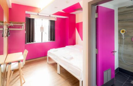 Generator London gay-friendly hotel room. Bright pink walls, bed, desk, and shower room. Pet-friendly hostel for gay men in London.